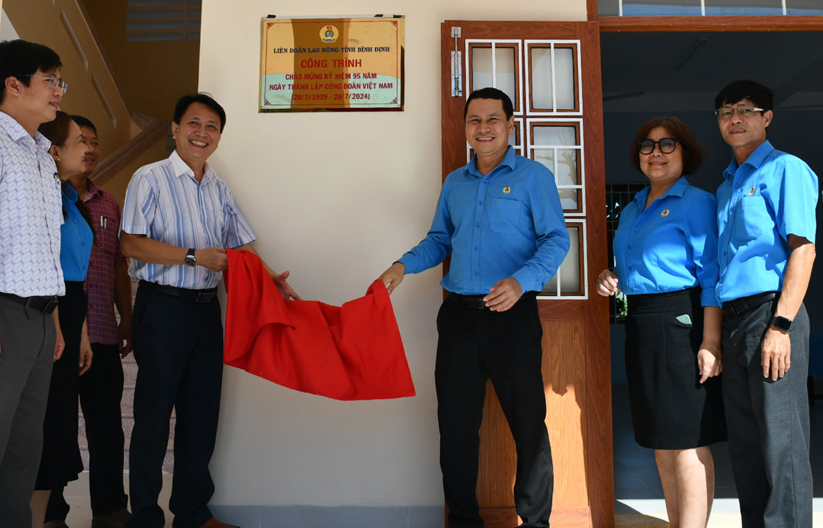Chủ tịch LĐLĐ Bình Định Hà Duy Trung và lãnh đạo Phòng Giáo dục - Đào tạo Quy Nhơn gắn biển Trường Phước Mỹ. Ảnh: Xuân Nhàn.