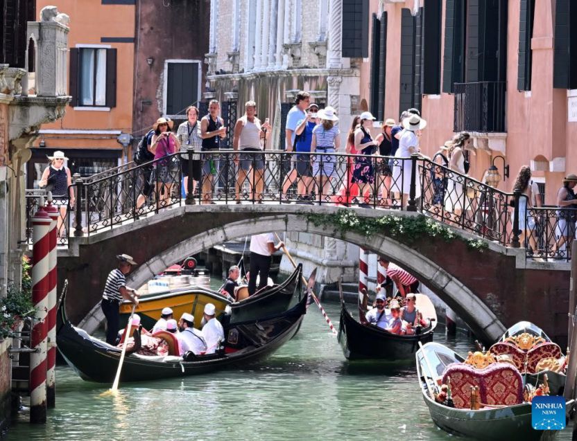 Khách du lịch ngắm cảnh bằng thuyền gondola ở Venice, Italia, ngày 18.7.2024. Ảnh: Xinhua
