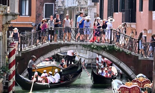 Khách du lịch ngắm cảnh bằng thuyền gondola ở Venice, Italia, ngày 18.7.2024. Ảnh: Xinhua
