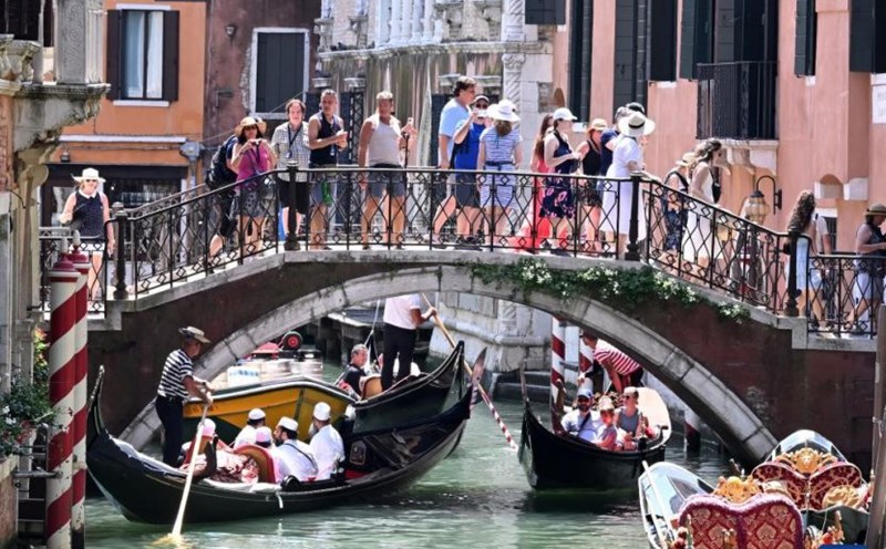 Khách du lịch ngắm cảnh bằng thuyền gondola ở Venice, Italia, ngày 18.7.2024. Ảnh: Xinhua
