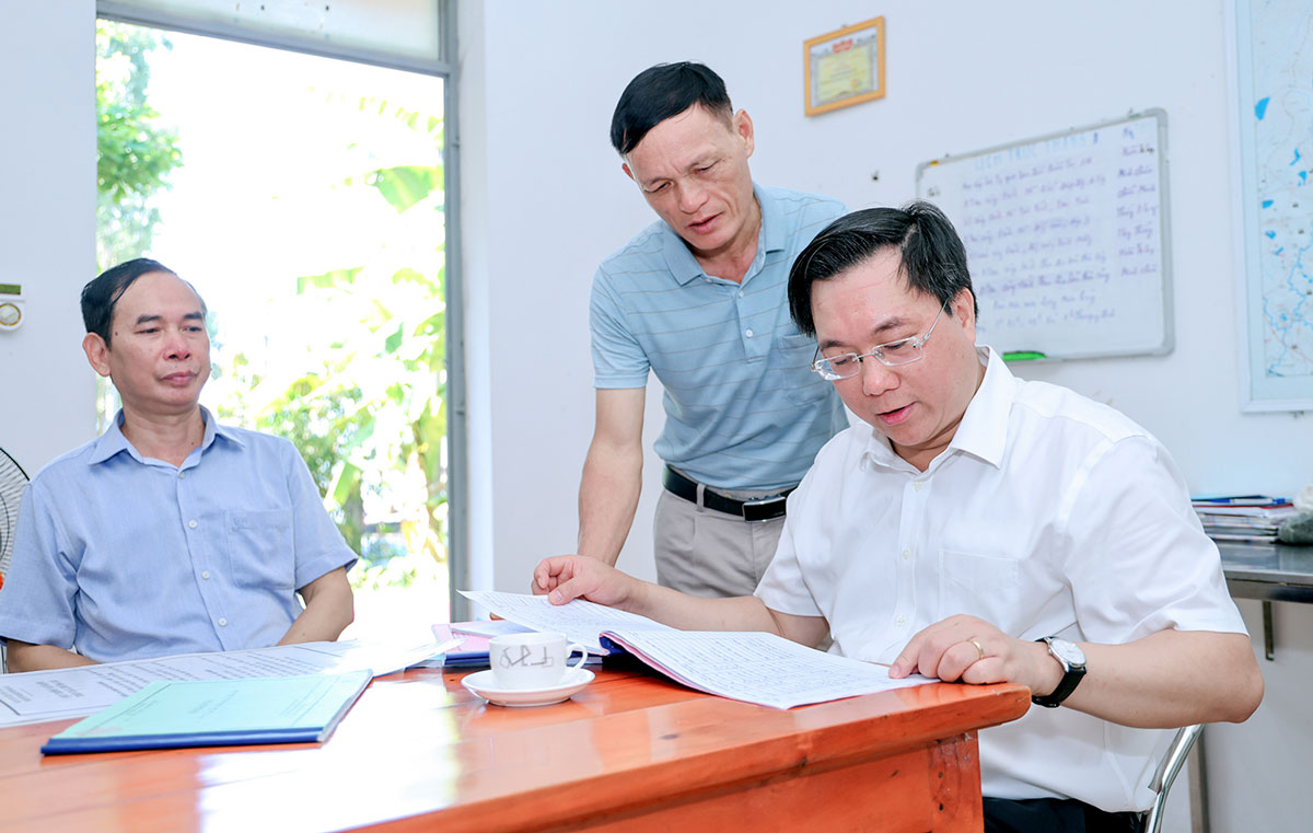 Tran Duy Dong inspects the operation logbook of Phuc Yen Water Resources Joint Stock Company. Photo: Khanh Linh