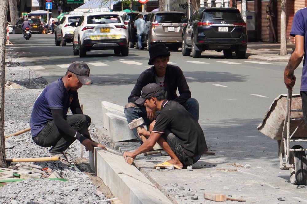 Một số công nhân làm việc giữa cái nóng 37 độ C. Anh Thái Văn Hùng, công nhân thi công vỉa hè trên đường Huỳnh Thúc Kháng cho biết những ngày nay trời động, thời tiết nắng mưa thất thường nên phải trang thủ làm lúc trời còn nắng.