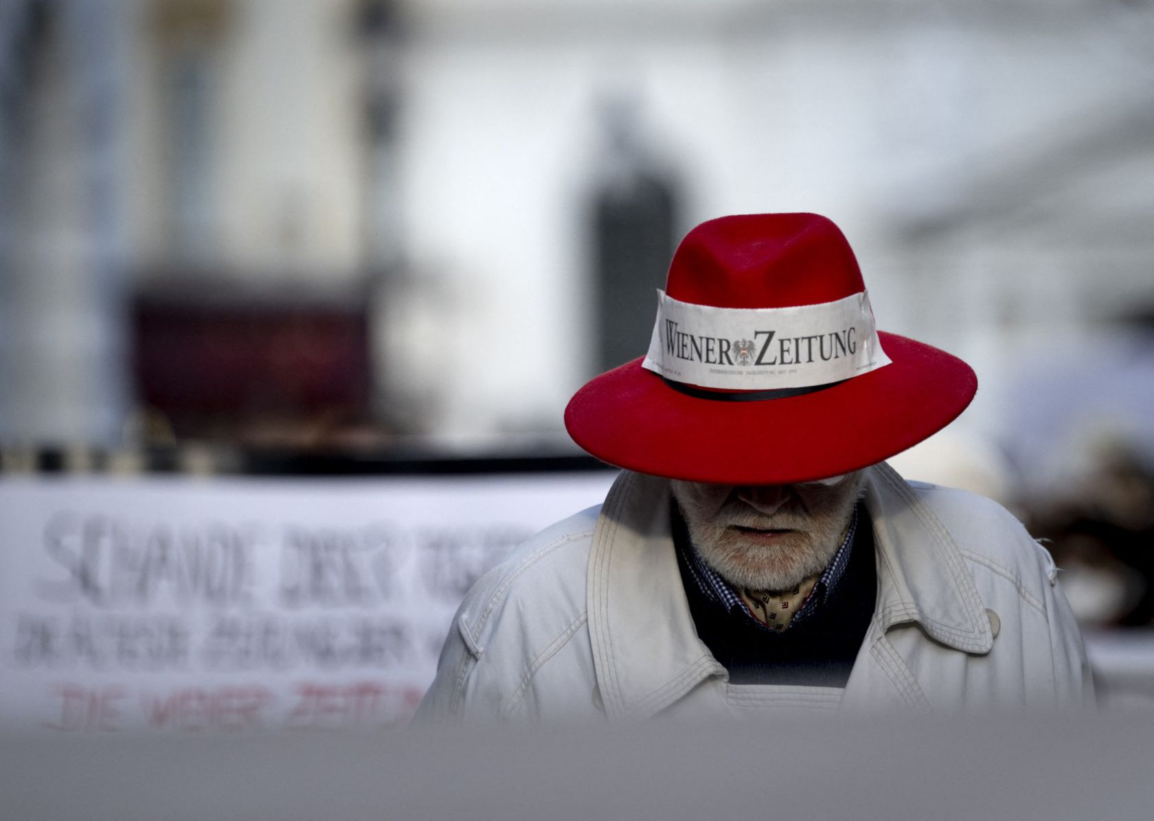 A man wearing a hat with a Wiener Zeitung logo at Vienna, Austria. Photo: AFP