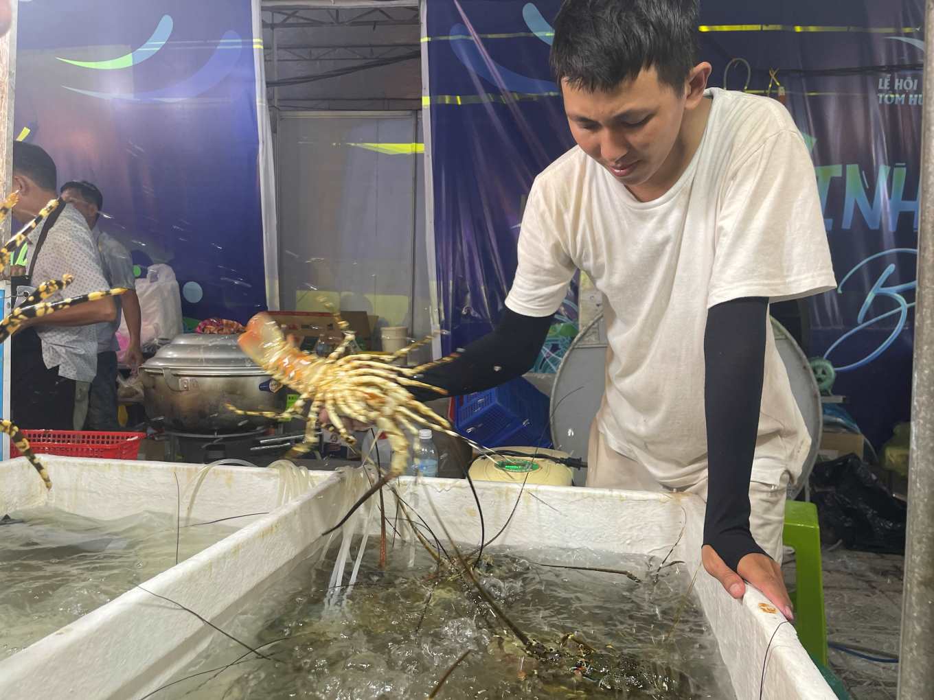 Mr. Nguyễn Công Chánh - Owner of the crab stall at the Cam Ranh Crab Festival selects fresh crabs, priced at 950,000 VND/kg for customers. Photo: Phương Linh