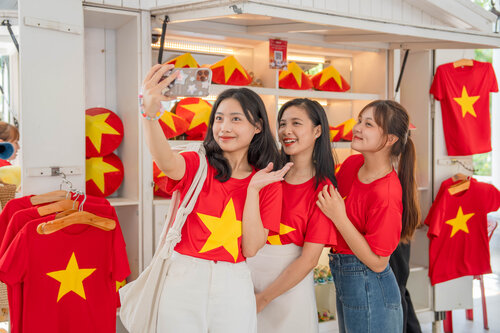 Giới trẻ thích thú khi mặc áo cờ đỏ sao vàng checkin tại Đà Nẵng. Ảnh: H. Hà