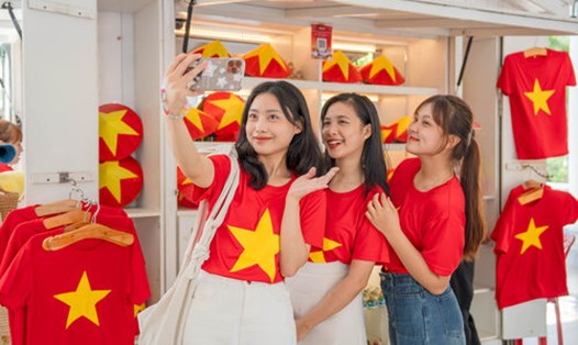 Giới trẻ thích thú khi mặc áo cờ đỏ sao vàng checkin tại Đà Nẵng. Ảnh: H. Hà