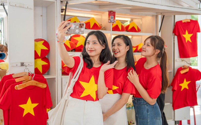 Giới trẻ thích thú khi mặc áo cờ đỏ sao vàng checkin tại Đà Nẵng. Ảnh: H. Hà