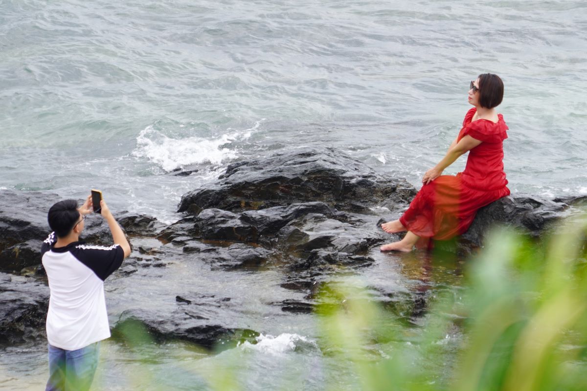 Many people take souvenir photos right on the beach, or find rocks to get more beautiful angles. Photo: Thanh An