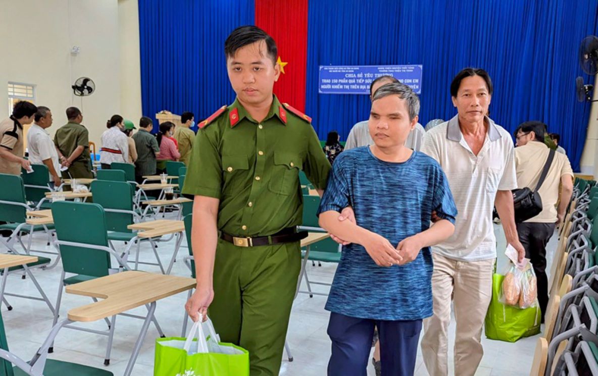 Kindly leading the blind at the gift giving ceremony. Photo: Nghiem Tuc