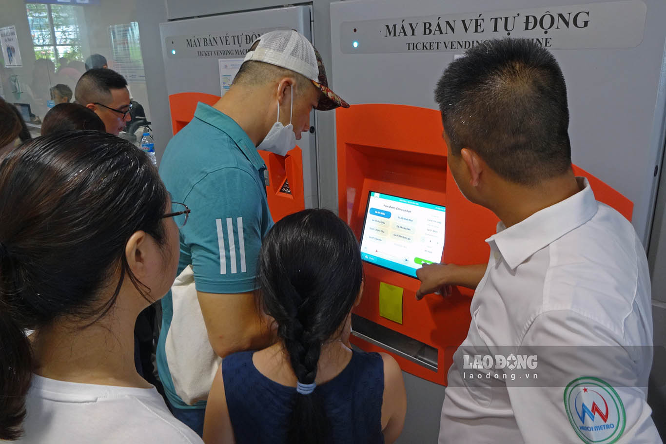 Hanoi Metro staff are on duty at automatic ticket machines to promptly assist passengers.