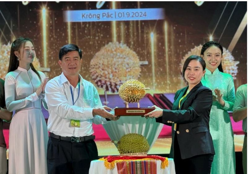 Ông Nguyễn Thiên Văn - Phó Chủ tịch UBND tỉnh Đắk Lắk, trao trái sầu riêng mạ vàng cho người trúng đấu giá. Ảnh: Trung Tân

