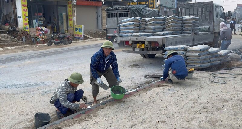 Công nhân tăng ca hoàn thiện vỉa hè Tỉnh lộ 414C qua huyện Ba Vì, Hà Nội. Ảnh: Hoàng Lộc