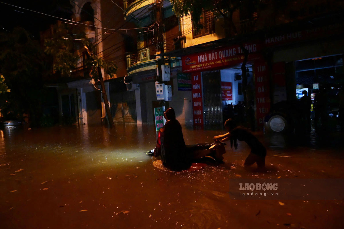 Nước ngập ngang xe máy. Ảnh: Hà Vi