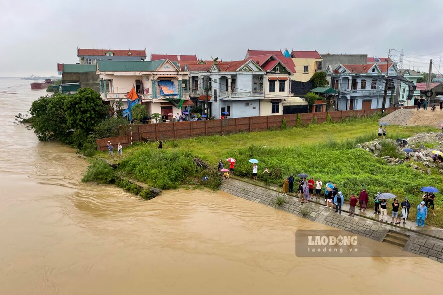 The floodwaters of the Lo River rose, and many curious people still went to the riverbank to see the ship stuck at Vinh Phu Bridge. Photo: To Cong.