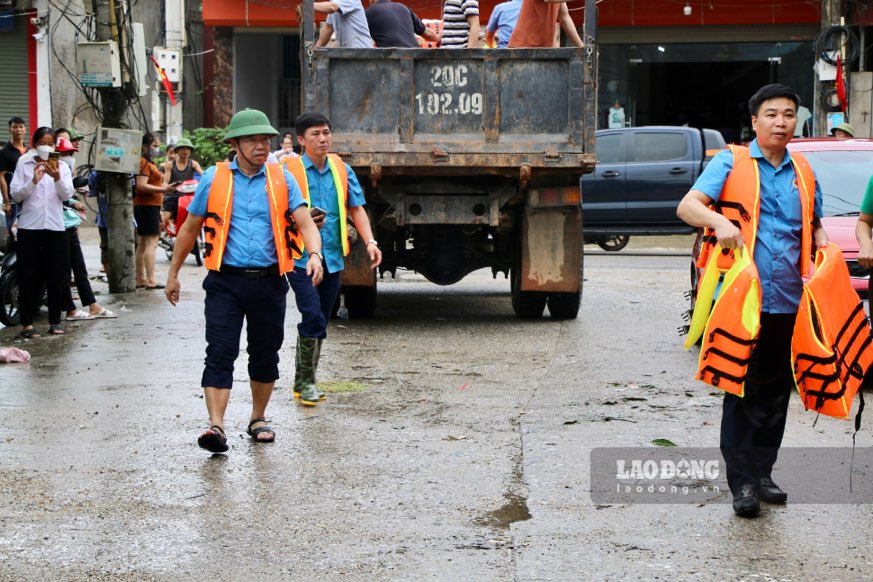 Ông Đoàn Mạnh Thắng (người mặc áo phao đầu tiên, bên trái) đi trực tiếp đến nhà người dân vùng ngập lụt xã Thượng Đình (Phú Bình).