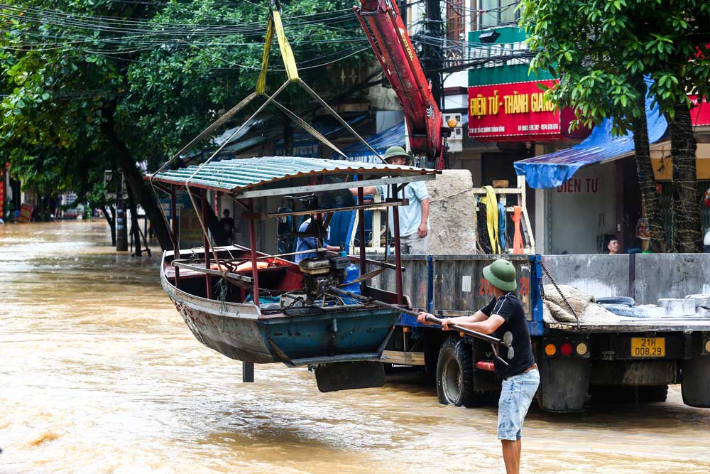 Authorities and people help bring boats in for rescue