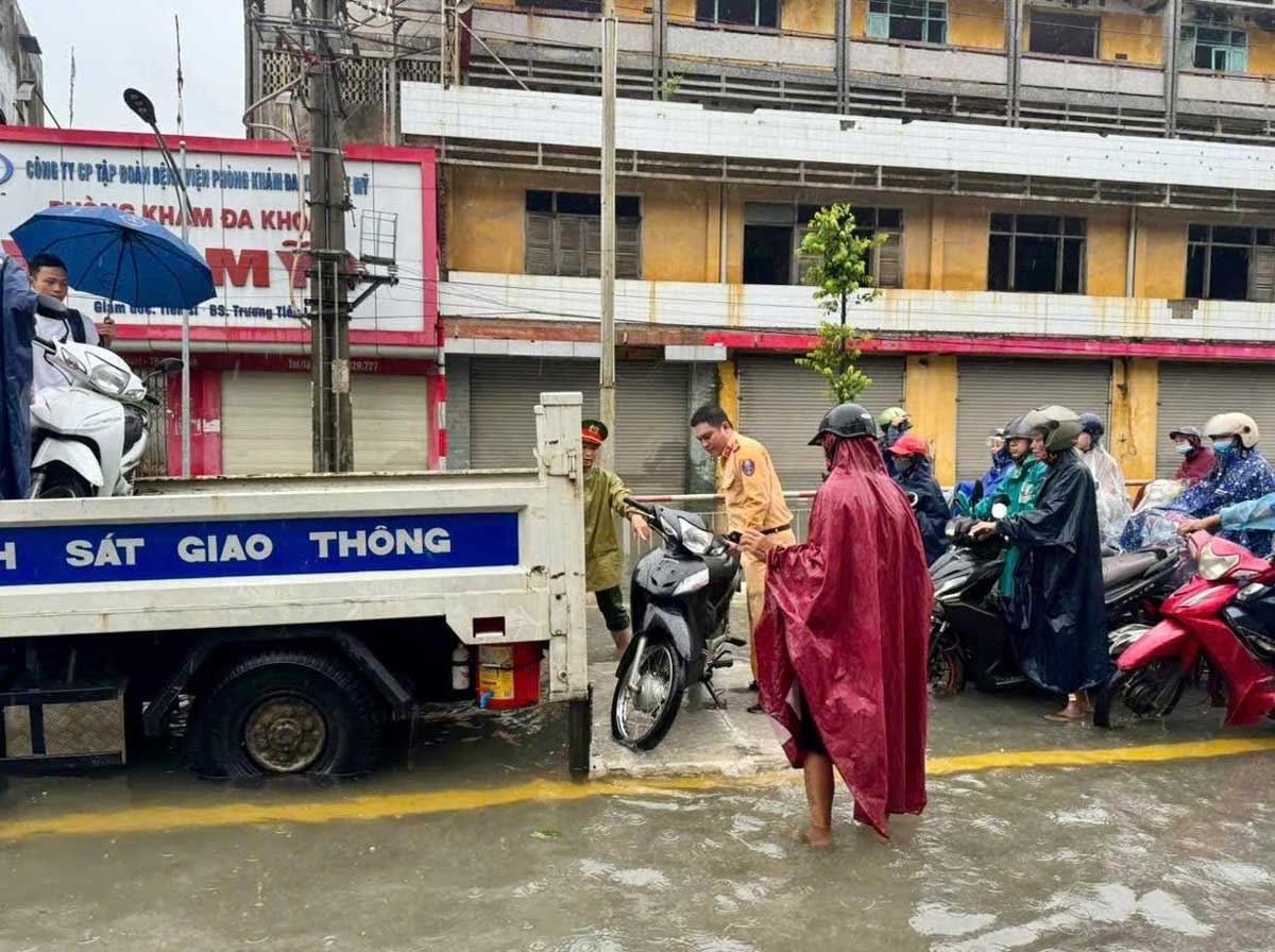 Nam Dinh Provincial Police assist people through flooded areas at the foot of Do Quan Bridge. Photo: Nam Dinh Provincial Police