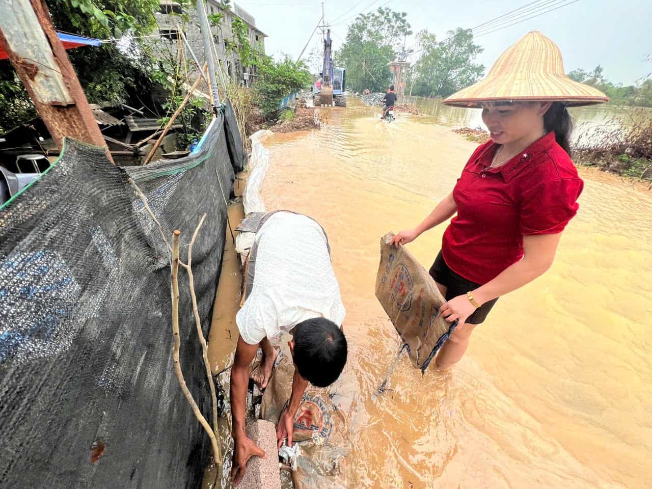 Trưa 10.9, vợ chồng chị Ý đang loay hoay đắp kè, ngăn cho dòng nước đỡ xoáy vào nhà. 