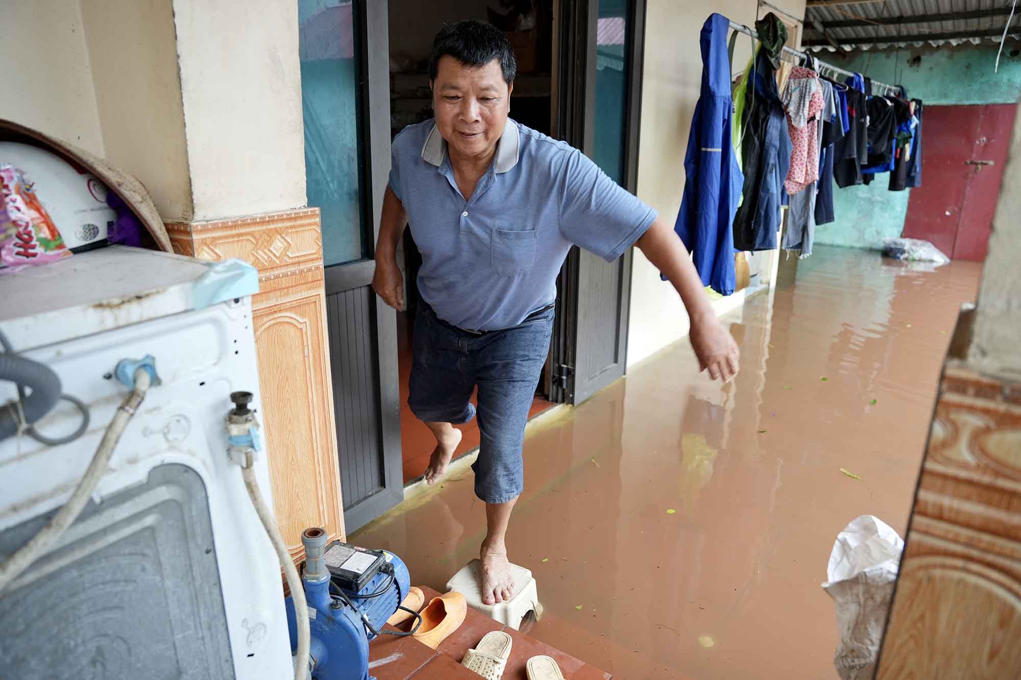 Gia đình ông Lộc hiện đã bị ngập đến sân, nước tràn vào khu vực bếp. Ảnh: Hữu Chánh