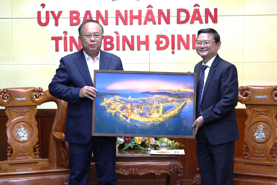 Phó Chủ tịch UBND tỉnh Bình Định Nguyễn Tự Công Hoàng (phải) tặng quà lưu niệm cho Cục trưởng Cục Quản lý công sản Phútthasin Hươngthavông. Ảnh: Sỹ Tiên