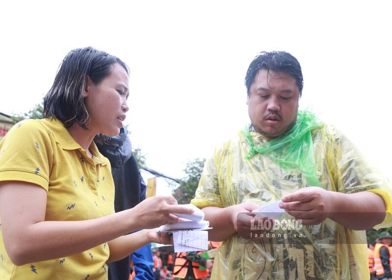 People distribute information cards to provide food to flooded areas. Photo: Lam Thanh