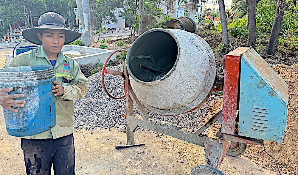 Workers mixing fresh concrete. Photo: Duy Tuan