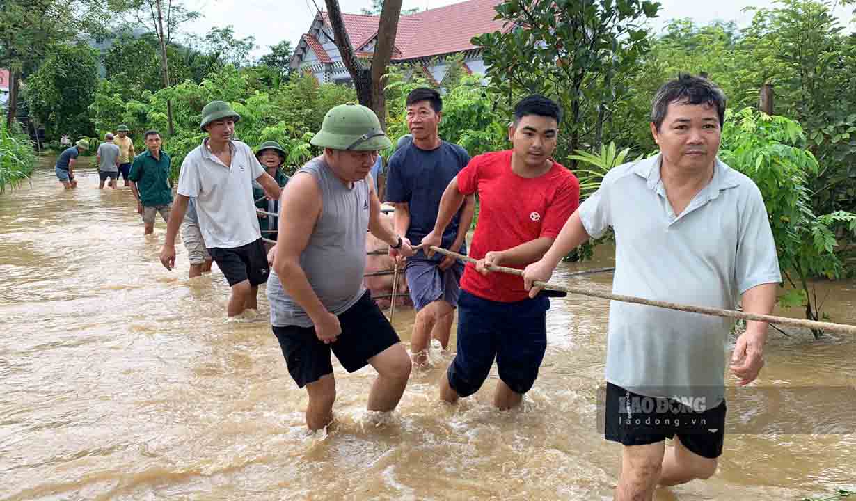 Người dân xã Quyết Thắng bì bõm trong nước lũ di chuyển tài sản, vật nuôi.