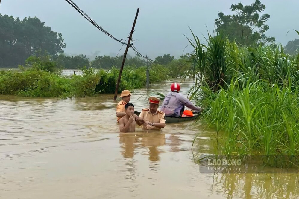 Cong an huyen Cam Khe ho tro di doi nguoi dan ra khoi khu vuc ngap lut. Anh: To Cong.