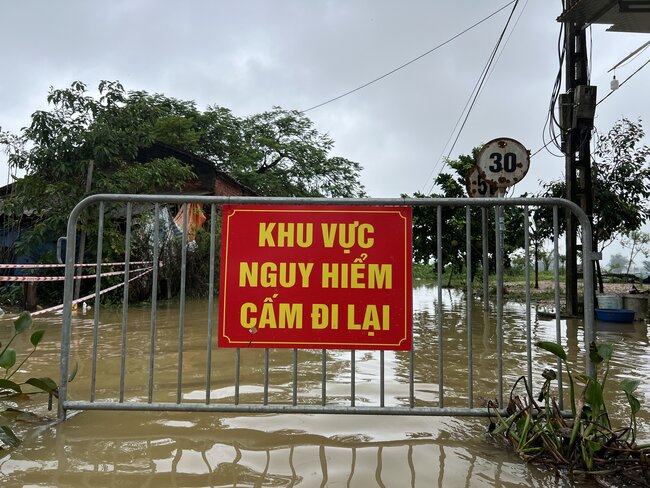 Canh bao nguy hiem khi nuoc lu dang cao, tran vao cac thon cua xa Nam Phuong Tien. Anh: Cuong Ngo 