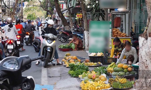 Tiểu thương bày hàng trên vỉa hè đường Đề Thám. Ảnh: Bích Ngọc