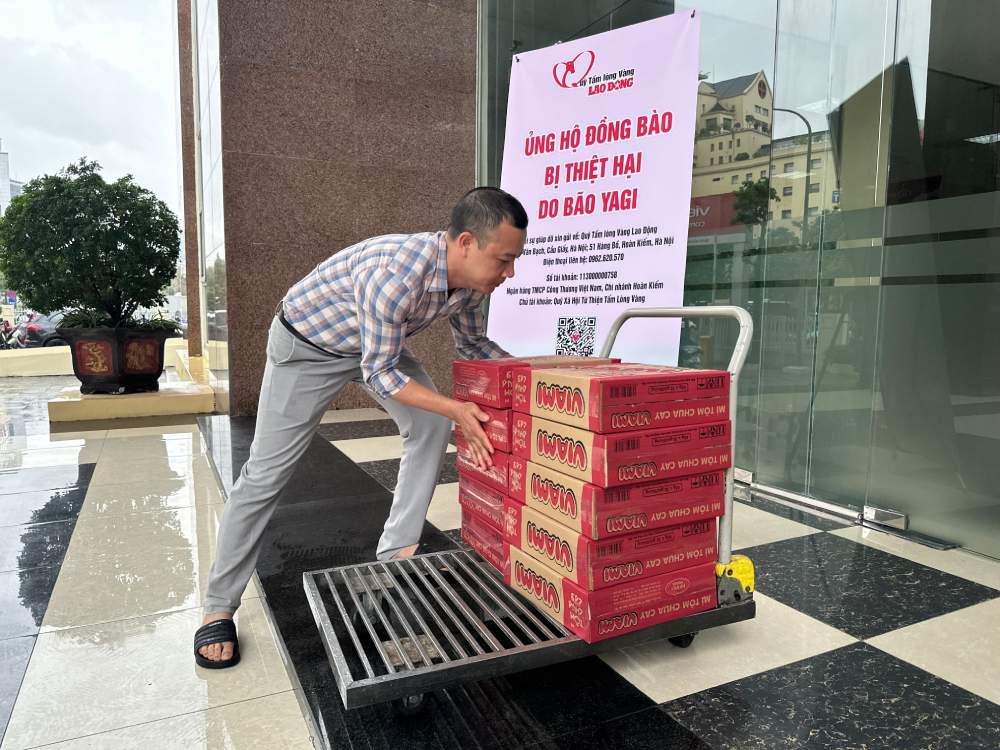 Đại diện Quỹ Tấm lòng Vàng tiếp nhận mì ủng hộ đồng bào vùng bão lũ từ Công ty TNHH Lương thực Hà Việt. Ảnh: Hà Việt