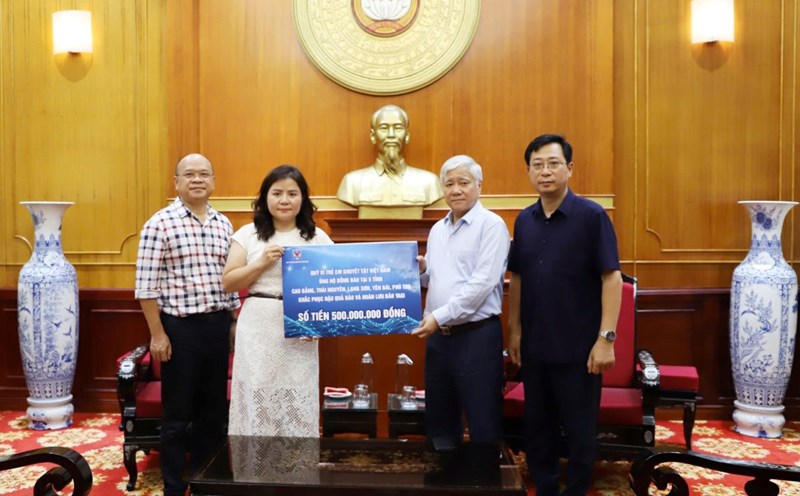 Chủ tịch Ủy ban Trung ương MTTQ Việt Nam Đỗ Văn Chiến tiếp nhận tiền ủng hộ bão lũ từ Quỹ  Vì trẻ em khuyết tật Việt Nam. Ảnh: Phạm Đông