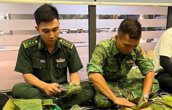 Cán bộ, chiến sĩ Biên phòng Đà Nẵng gói bánh chưng gửi tặng người dân vùng lũ. Ảnh: Doãn Quang