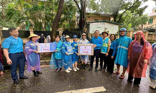Ông Phạm Quang Thanh - Chủ tịch Liên đoàn Lao động Thành phố Hà Nội (thứ 5 từ phải sang) cùng lãnh đạo Công đoàn ngành Xây dựng Hà Nội thăm, động viên công nhân tham gia khắc phục thiệt hại do cơn bão số 3 gây ra. Ảnh: Việt Lâm