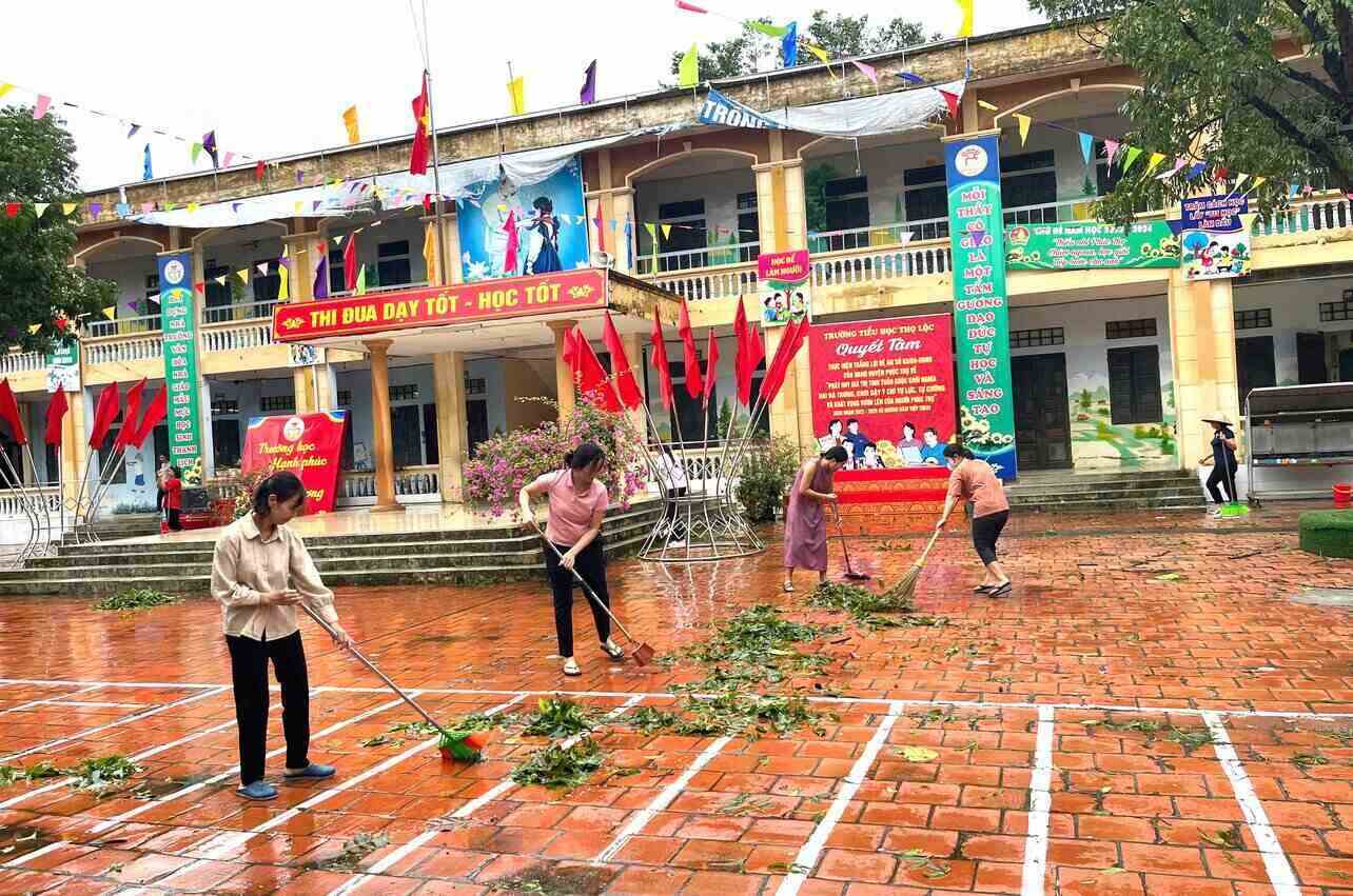 Cán bộ, đoàn viên Công đoàn huyện Phúc Thọ dọn dẹp, khắc phục hậu quả bão số 3 tại xã Thọ Lộc. Ảnh: CĐCS