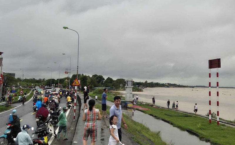 Chiều 11.9, mực nước sông Hồng khu vực đình Chèm, Bắc Từ Liêm, Hà Nội dâng cao chưa từng có. Nhiều người dân hiếu kỳ vây quanh khu vực đê điều nhìn dòng lũ. Ảnh: Phan Anh