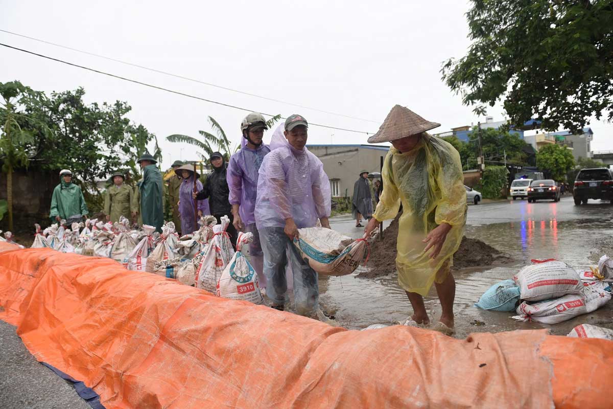 Những bao tải cát được người dân xếp thành bờ ngăn nước khu vực chân cầu Tân Phong. Ảnh: Lương Hà