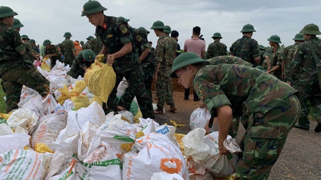 Ngay từ sáng sớm, người dân xã Đường Lâm đã kêu gọi mọi người cùng nhau đóng góp bao tải đựng đất để góp phần hộ đê. Ảnh: Đăng Khôi