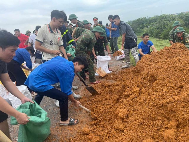 Thanh niên tham gia đắp đê. Ảnh: Đăng Khôi