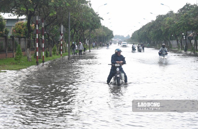 Mực nước dâng cao khiến việc đi lại của các công nhân sau giờ tan làm khá vất vả.