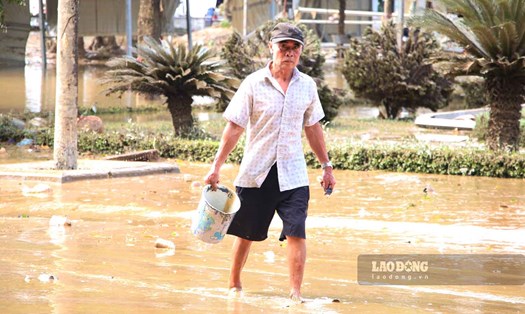 Người dân TP Tuyên Quang múc nước sông dọn nhà sau lũ khi điện nước chưa thể cấp lại.