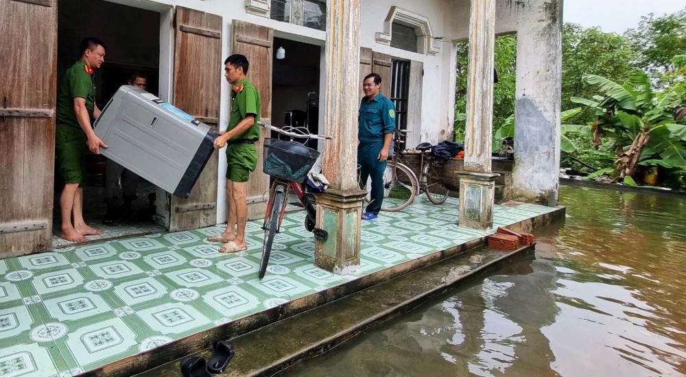 Công an cơ sở đi từng ngõ, gõ từng nhà, hỗ trợ từng gia đình chống lũ. Ảnh: CANB