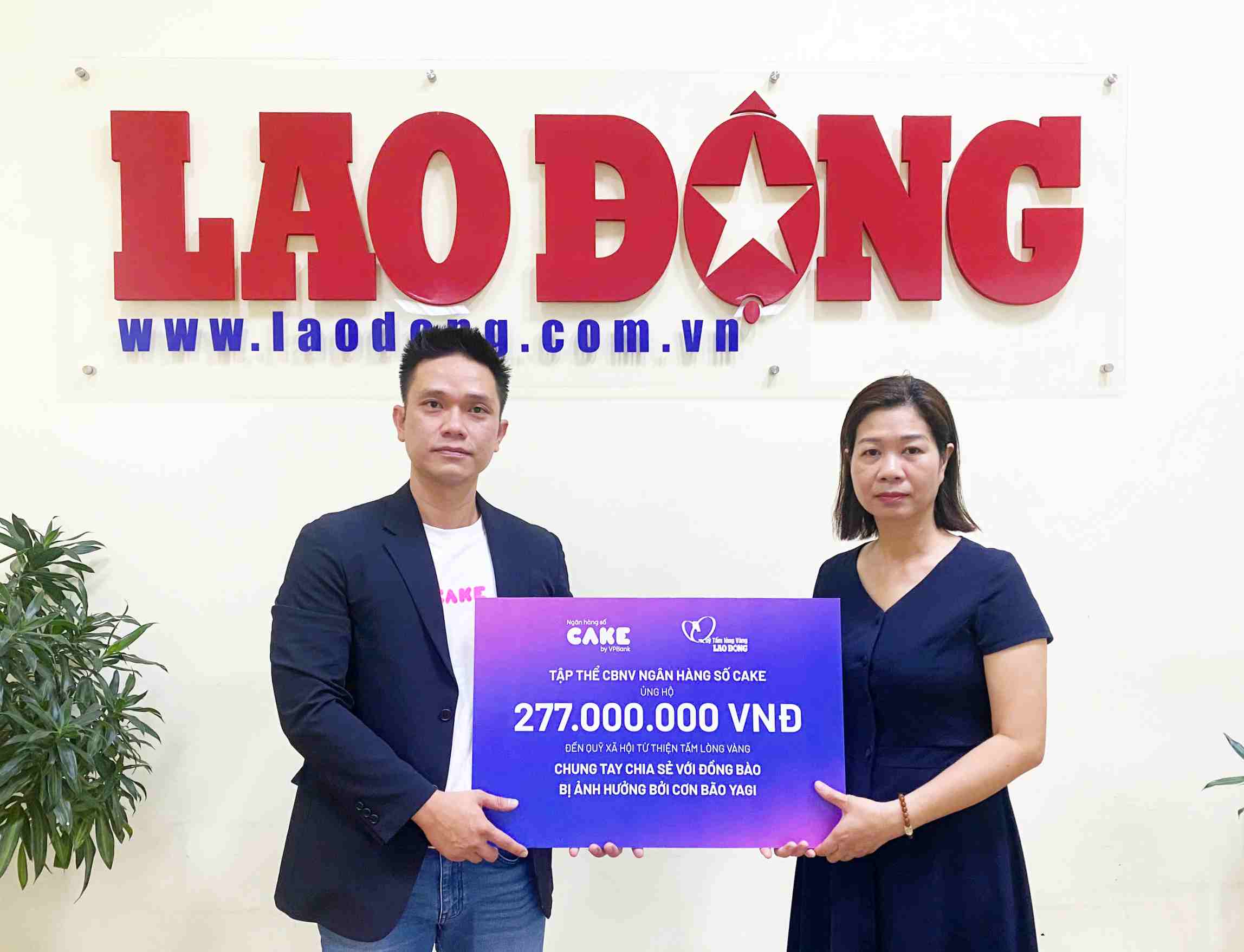 Đại diện Ngân hàng số Cake trao tiền hỗ trợ cho Quỹ Tấm lòng Vàng. Ảnh: Trà My