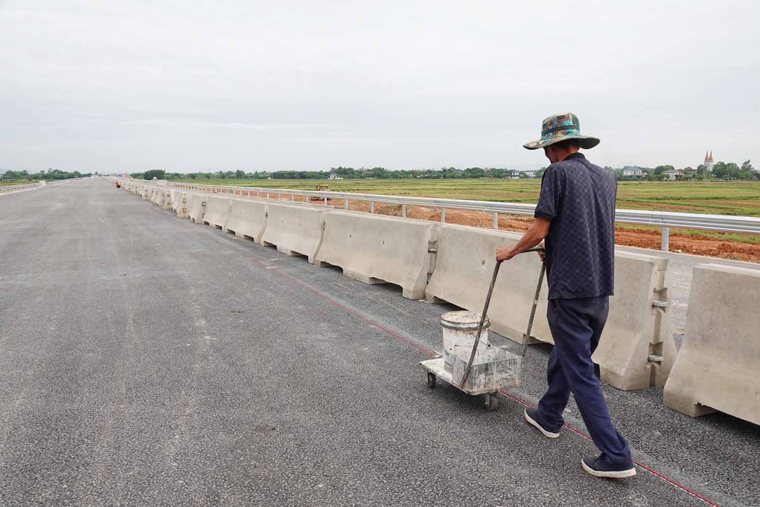 Cong nhan ke vach tren mat duong de dat dai phan cach cung duoc thang hang, can doi. Anh: Tran Tuan.