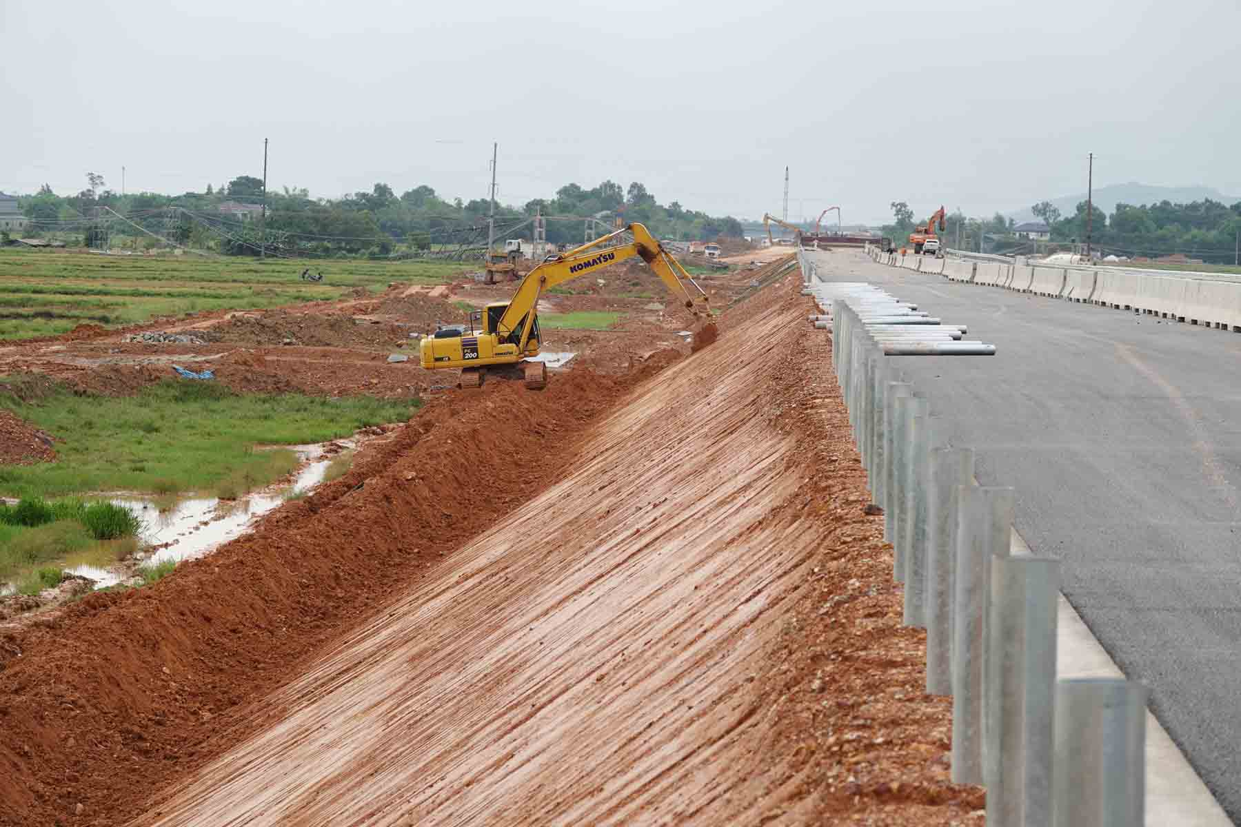 Máy đào đang nén chặt và làm đẹp tatuy đường. Ảnh: Trần Tuấn.