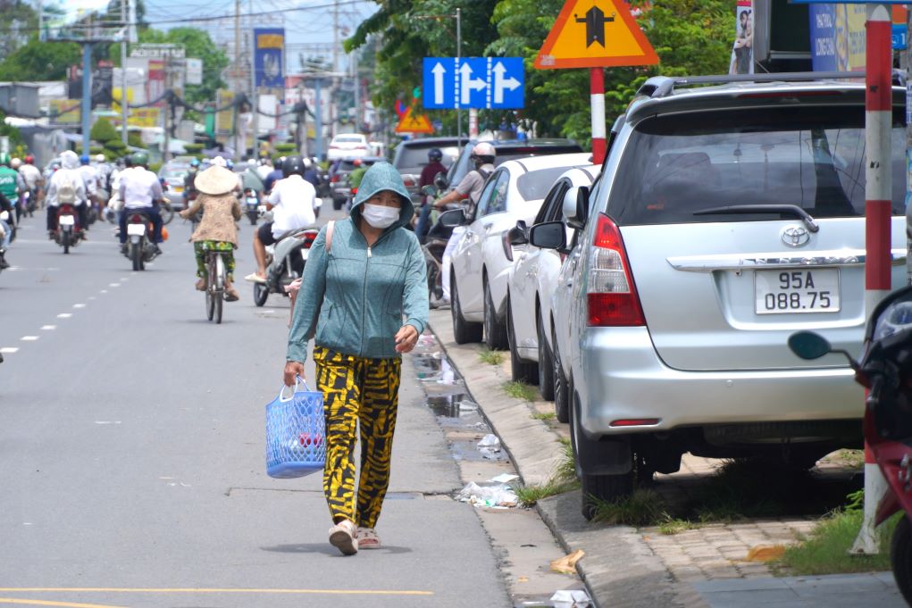 Ô tô đậu trên vỉa hè đẩy người đi bộ xuống lòng đường. Ảnh: Tạ Quang