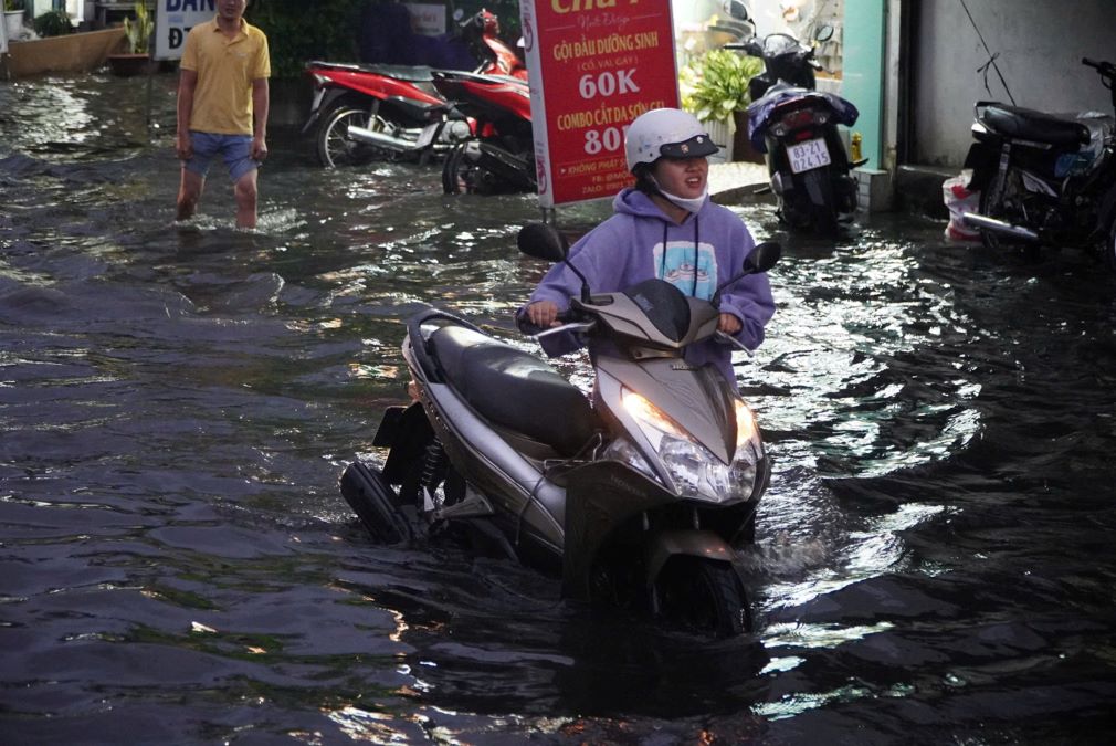 Nước ngập sâu khiến việc đi lại của người dân gặp nhiều khó khăn, nhiều phương tiện bị chết máy, người dân phải xuống dắt bộ.