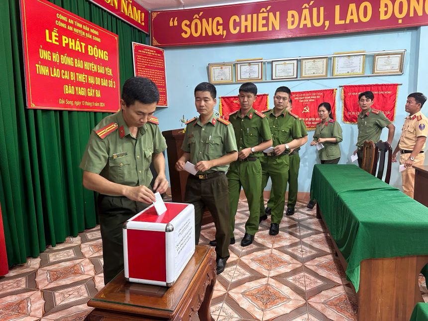 Cán bộ, chiến sĩ Công an huyện Đắk Song chia sẻ với bà con vùng bão lũ. Ảnh: Minh Quỳnh