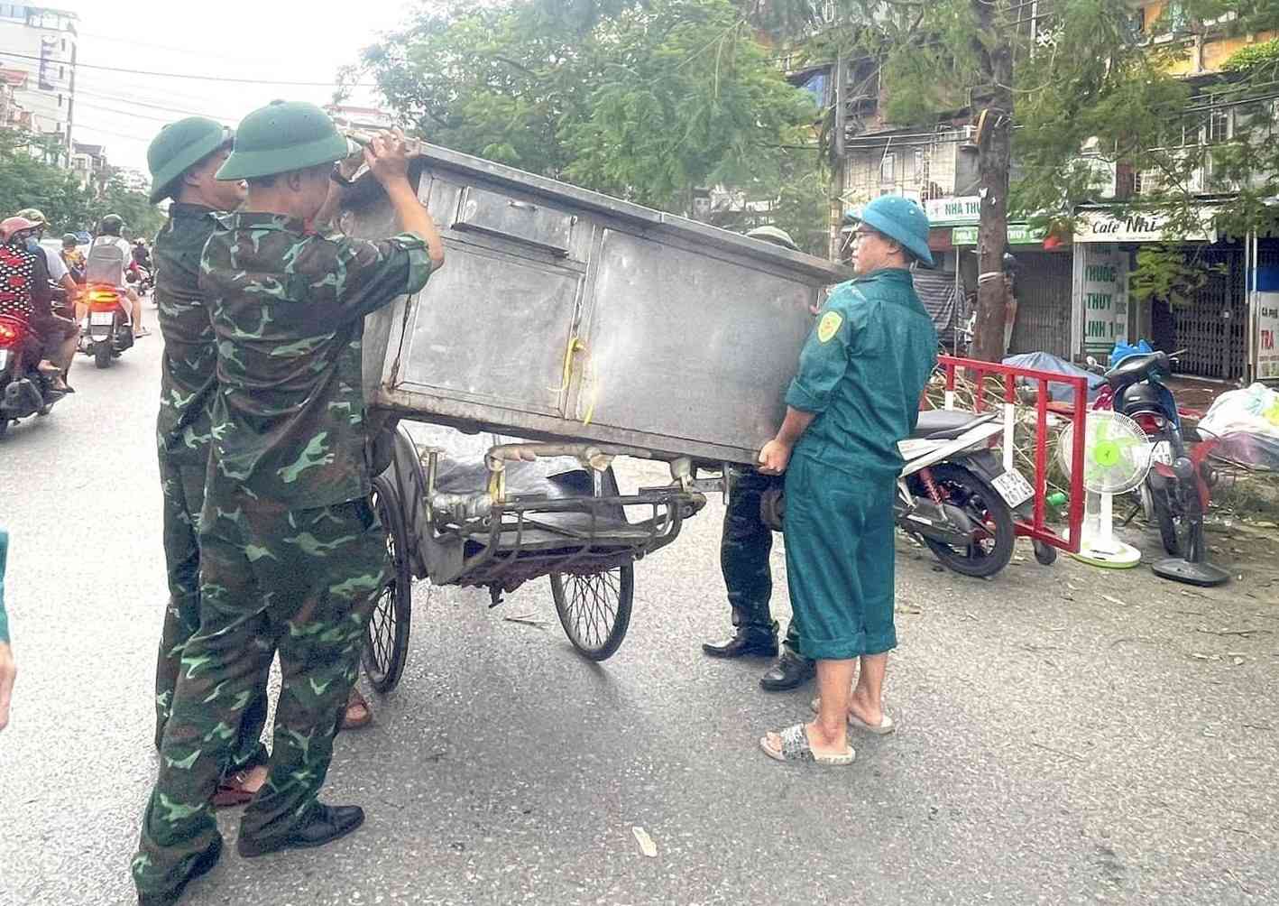 Cac luc luong chuc nang quan Ngo Quyen cung ho tro nhan dan van chuyen do dac den noi tam cu. Anh: Am vang Ngo Quyen