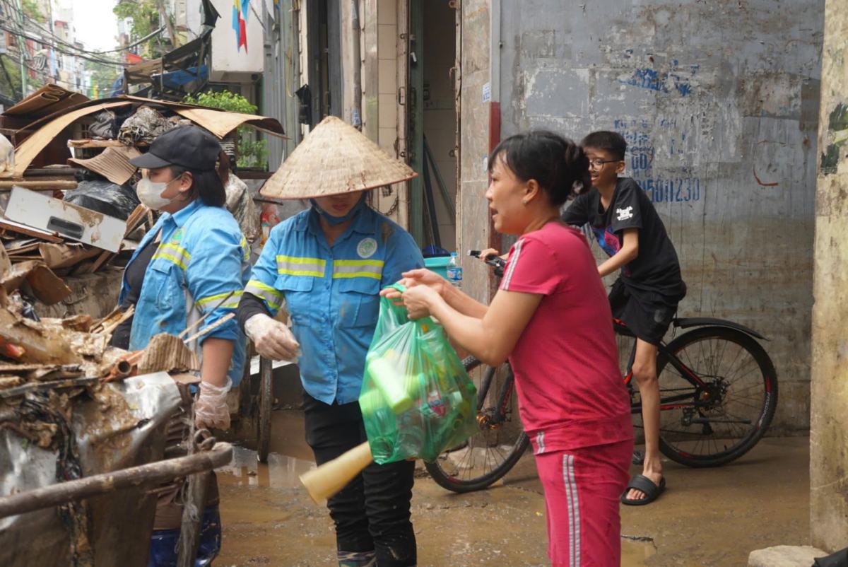 Người dân hỗ trợ nước uống cho người lao công. Ảnh: Công Hòa